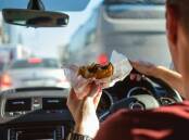 Is it illegal to eat while driving? Take the driving rules quiz. Picture Shutterstock
