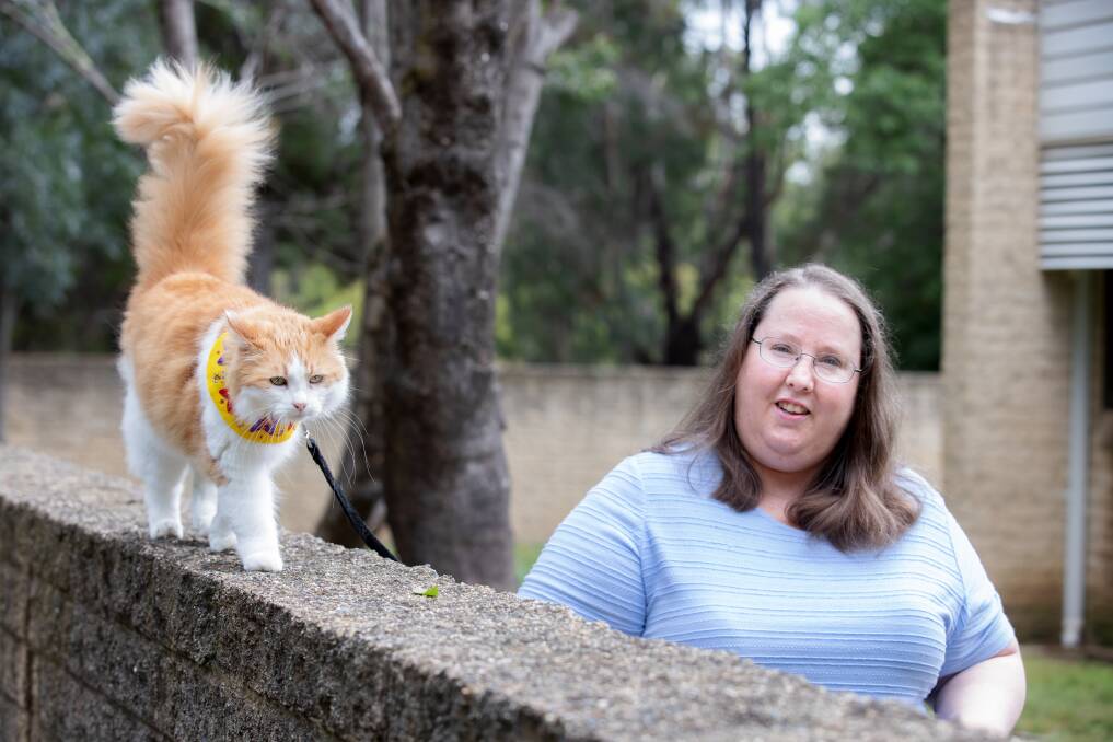 Emerson Riley with her rescue cat Mimi, who loves walking. She is trying to get laws changed so people can walk their cats on leads in the new suburbs designated as cat containment areas. Picture: Sitthixay Ditthavong