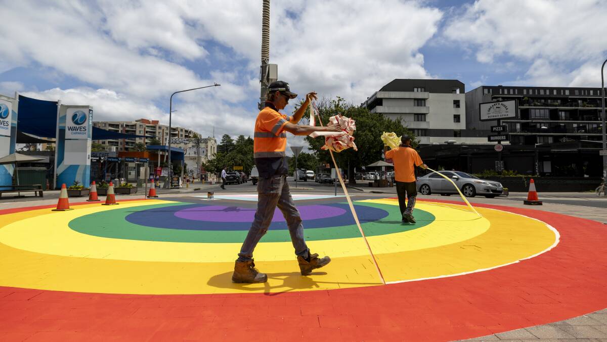 Workers remove tape from the newly painted Progress Pride Flag round about in Lonsdale Street, Braddon. Picture by Gary Ramage