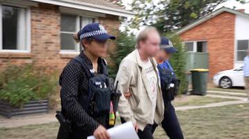 Police arrest a man after searching his home. Picture ACT Policing screenshot