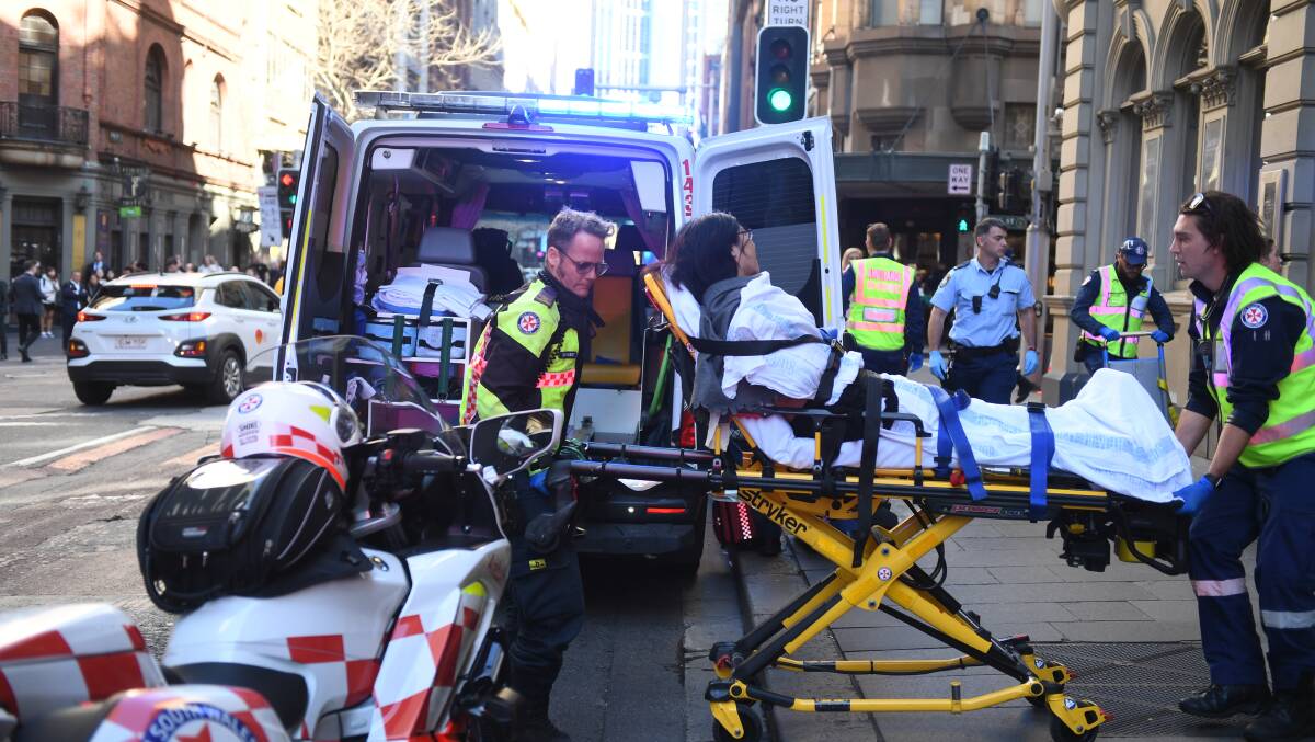 A woman is taken by ambulance from Hotel CBD at the corner of King and York Street. Picture: AAP