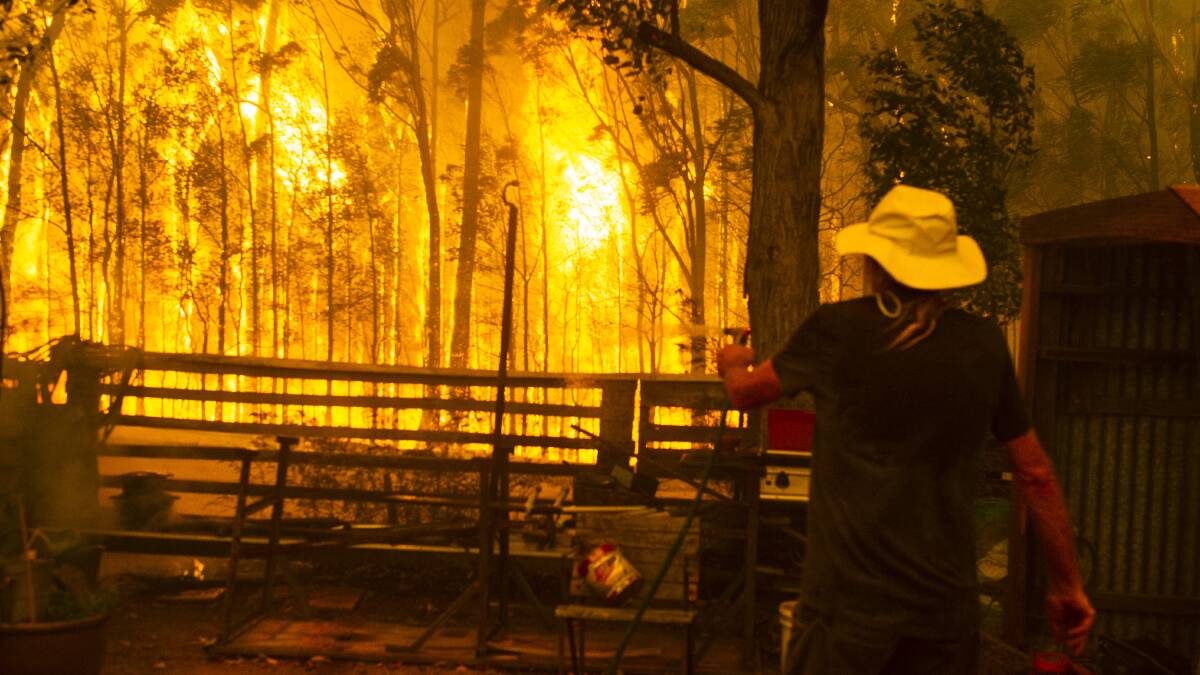 Michael Weekes protects his property west of Ulladulla from the Currowan fire on December 21. Flames reached 60 metres in height. Picture: Dion Georgopoulos