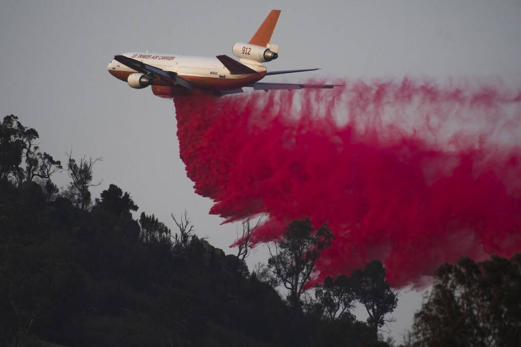 An air tanker near drops retardant near Tharwa in February. Picture: Dion Georgopoulos