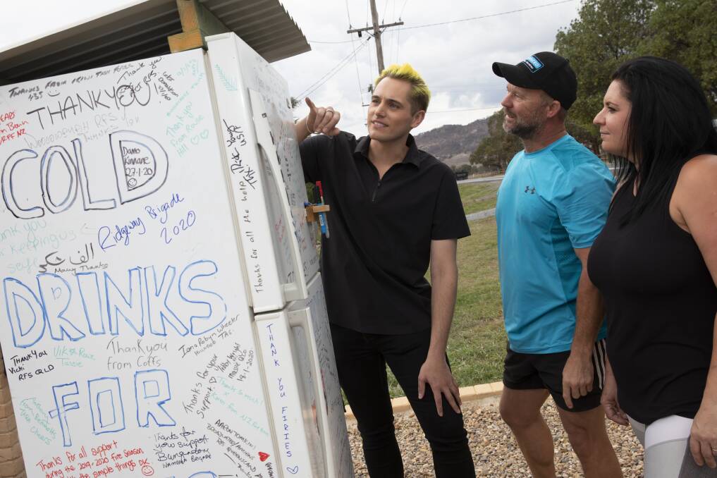 National Museum of Australia curator Craig Middleton, left, inspects the Bungendore roadside fridge with owners Scott and Claire Hooper. The fridge has been donated to the national collection. Picture: George Serras, National Museum of Australia