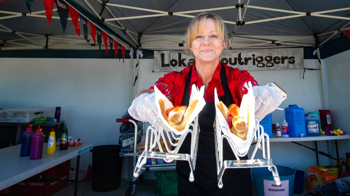 Kerrie Wilmot hands out sausage sangas as sausage sizzles return to Bunnings. Picture: Elesa Kurtz