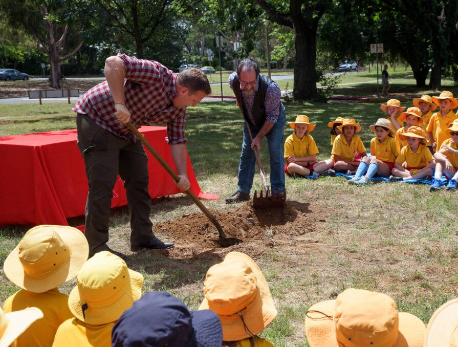 Former Forret Primary School student Richard Laity and retired teacher Michael Rosenberg dig up the time capsule Picture: Sitthixay Ditthavong 