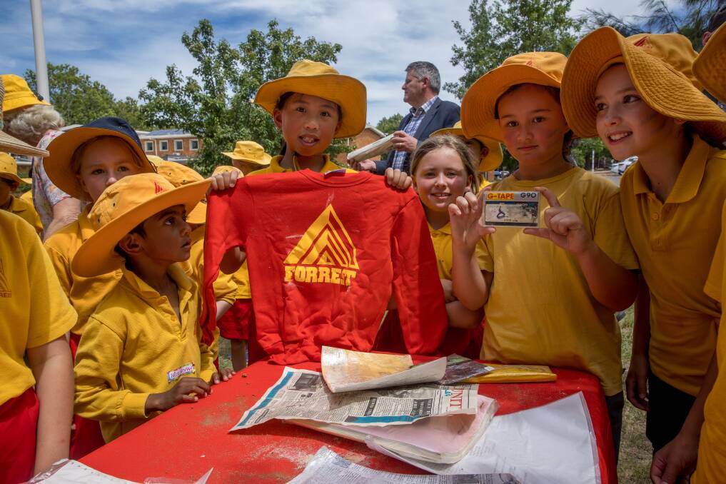 Abigail Lui and Veronica Horswell, centre, are joined by fellow Forrest Primary School students as they examine the contents of a time capsule which was buried out the front of the school in 1992. Picture: Sitthixay Ditthavong 