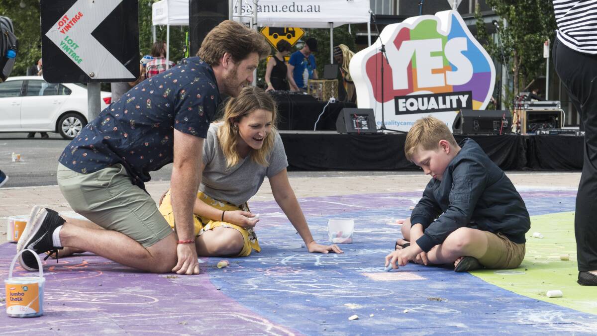 Daniel Little, Natalie Plummer, and Logan Little of Curtin take part in drawing with chalk on the rainbow roundabout. Picture by Elesa Kurtz