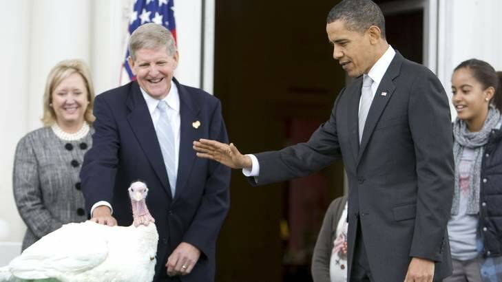 U.S. President Barack Obama, right, pardons the national Thanksgiving turkey, "Courage" during the annual White House turkey pardoning ceremony. Photo: Reuters