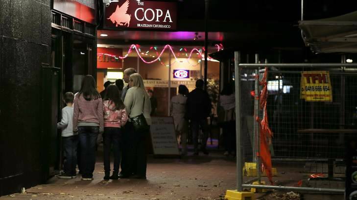A family looks into the reopened Copa Brazilian Churrasco restaurant in Dickson on Saturday night.