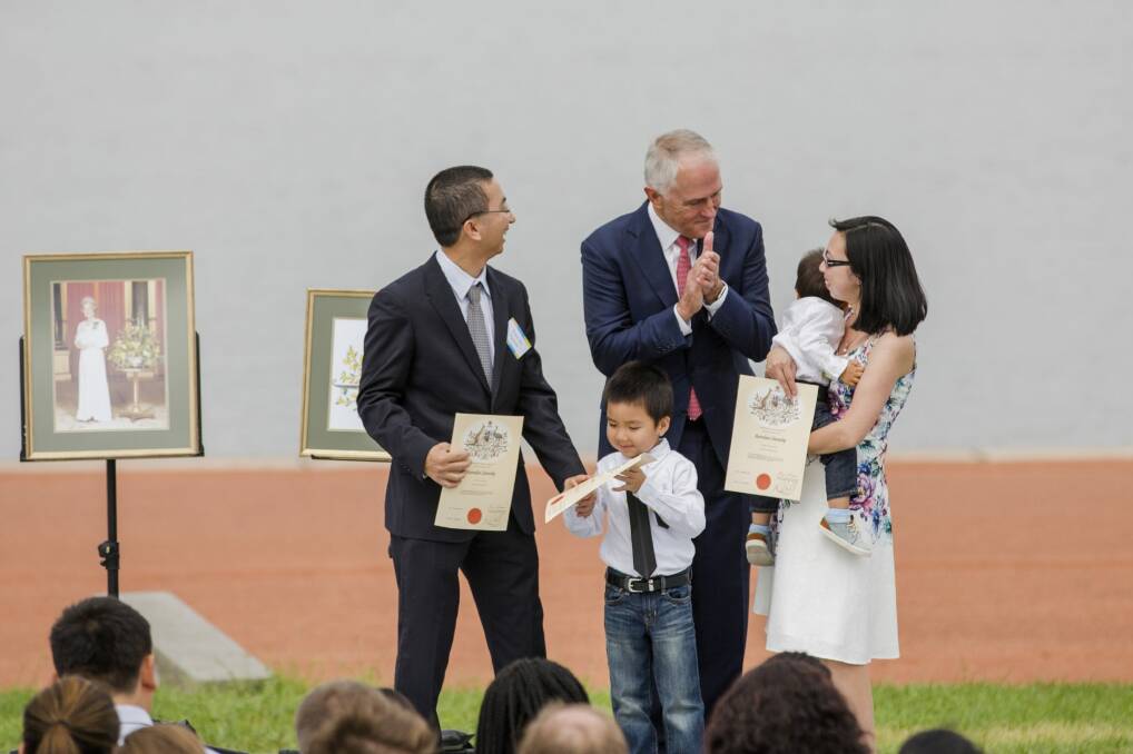 Prime Minister Malcolm Turnbull presents the Nguyen family with their citizenship certificates  Photo: Jamila Toderas
