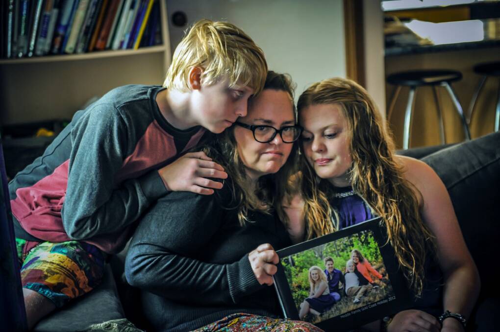 Stuart Heddle's wife Jenny, son Aidan,12 and daughter Jordan, 15 with a photo of their family in happier times. Photo: Karleen Minney
