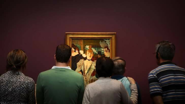 Visitors to the National Gallery of Australia look at the work La Goulue entering the Moulin Rouge during Toulouse Lautrec exhibition. Photo: Jeffrey Chan