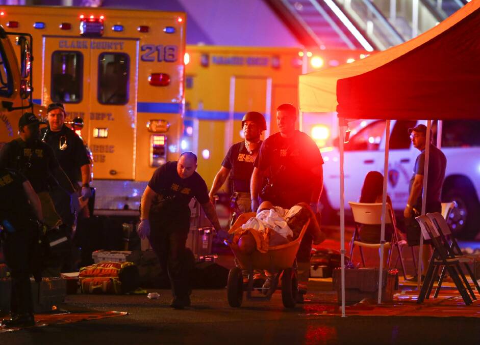 A wounded person is walked in on a wheelbarrow as Las Vegas police respond during an active shooter situation on the Las Vegas Strip in Las Vegas.  Photo: AP