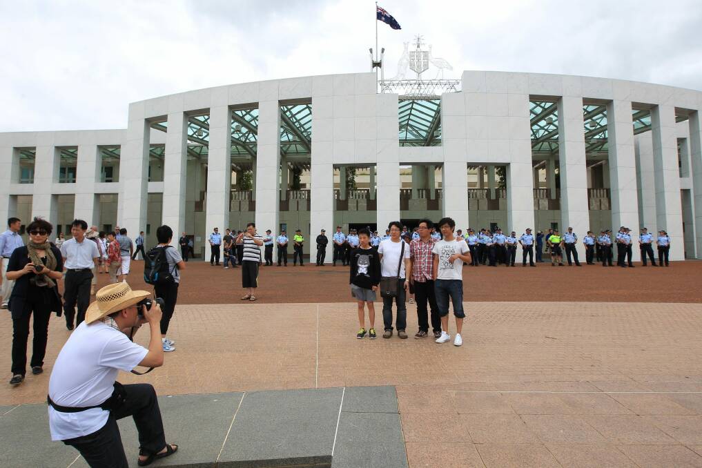 Tourists taking photos on the forecourt of Parliament House in Canberra. Photo: Alex Ellinghausen