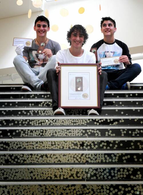Harley Russo (centre) in 2014 aged 14 with his triplet brothers Cameron and Dylan. A combined family effort has seen Harley secure every first coin struck since 2013. But this year, the family is further down the line.



 Photo: Karleen Minney