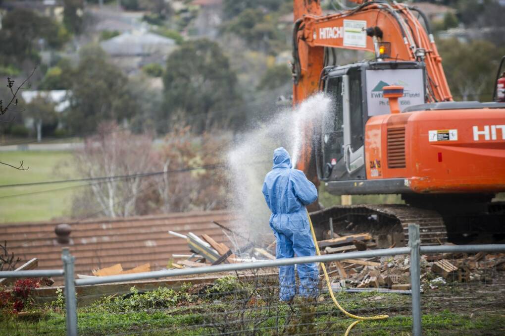 Workers demolish a Mr Fluffy home in Farrer. The government's offer to buy homes at market value ends on June 30. Photo: Rohan Thomson