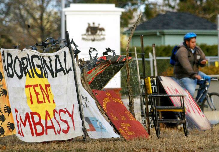 A cyclist passes the Aboriginal Tent Embassy. Photo: Will Burgess/Reuters