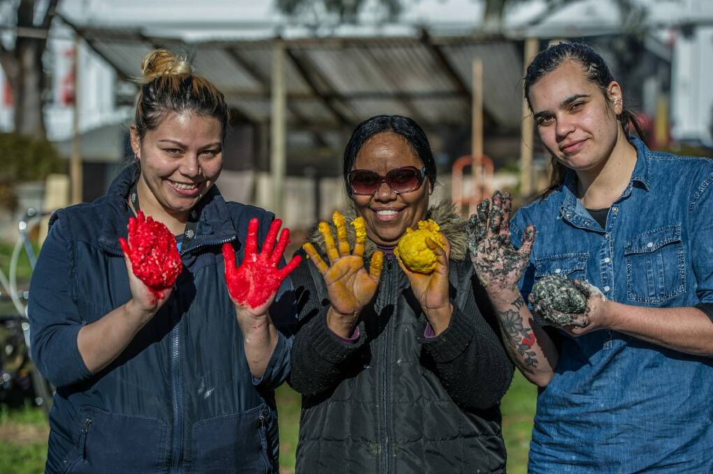 Amber Jarrett, Sylvia Rosas and Elizabeth Mitchell mixing dough in the colours of the Aboriginal flag at the damper cook-off during NAIDOC Week 2017. Photo: Karleen Minney