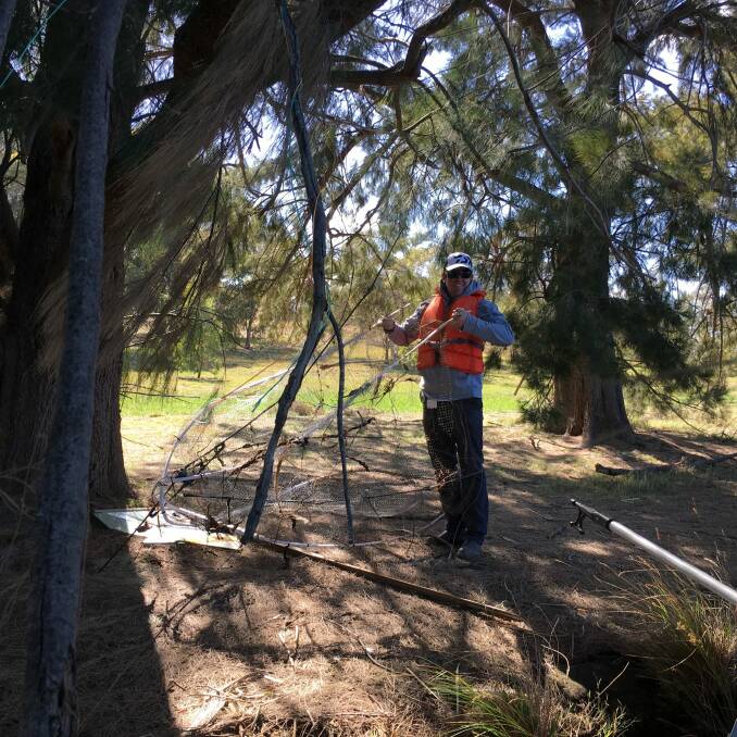 EPA officer Tim Gibb holds the "disturbingly large" fish trap found in Lake Burley Griffin. Photo: Supplied