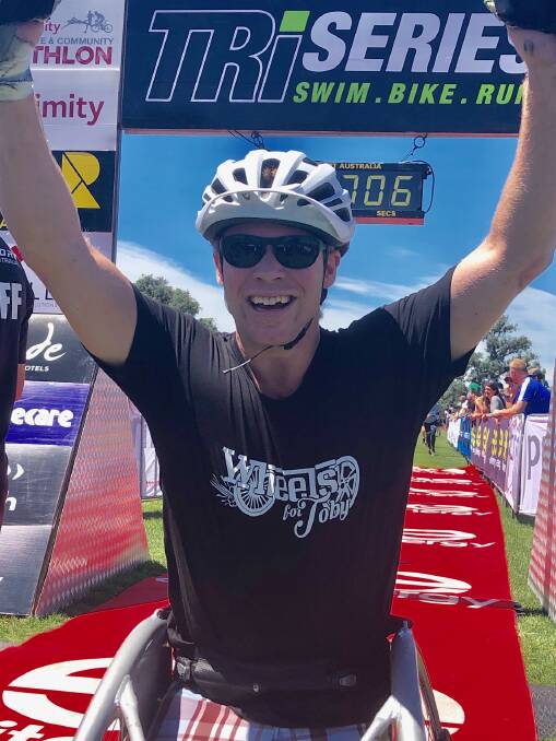 Double amputee Toby Lyndon crosses the finish line to complete his first triathlon. Photo: Jeremy Lasek