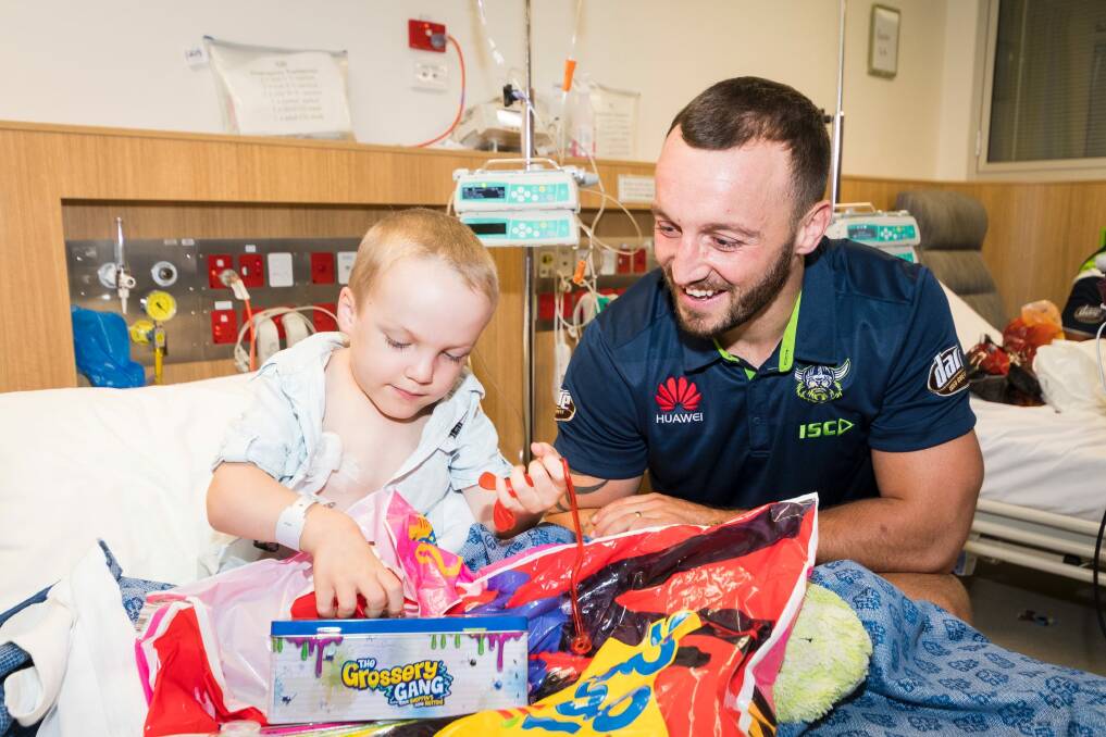 Raiders player Josh Hodgson and Kalten Nelson, 5, playing with new toys at the Canberra Hospital children's ward. Photo: Dion Georgopoulos