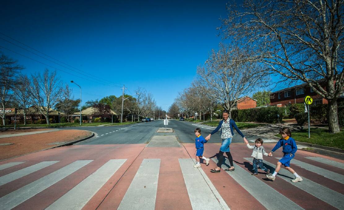 Mia Swainson of O'Connor and sons Xavier, 5, Tasman, 2, and Ashwyn, 7, cross the road at Lyneham Primary. Photo: Karleen Minney