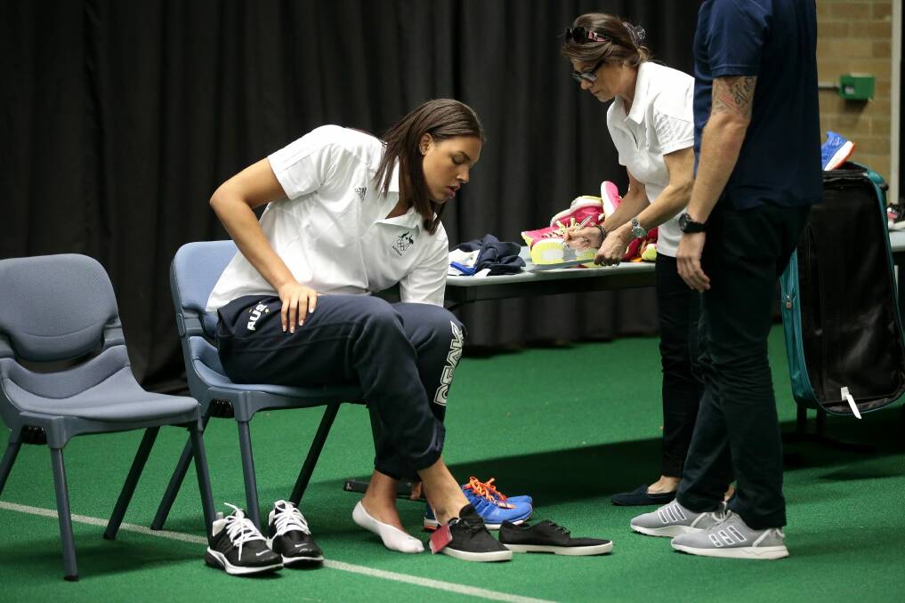 Opals player Liz Cambage tries on some shoes at the AIS on Tuesday.   Photo: Jeffrey Chan