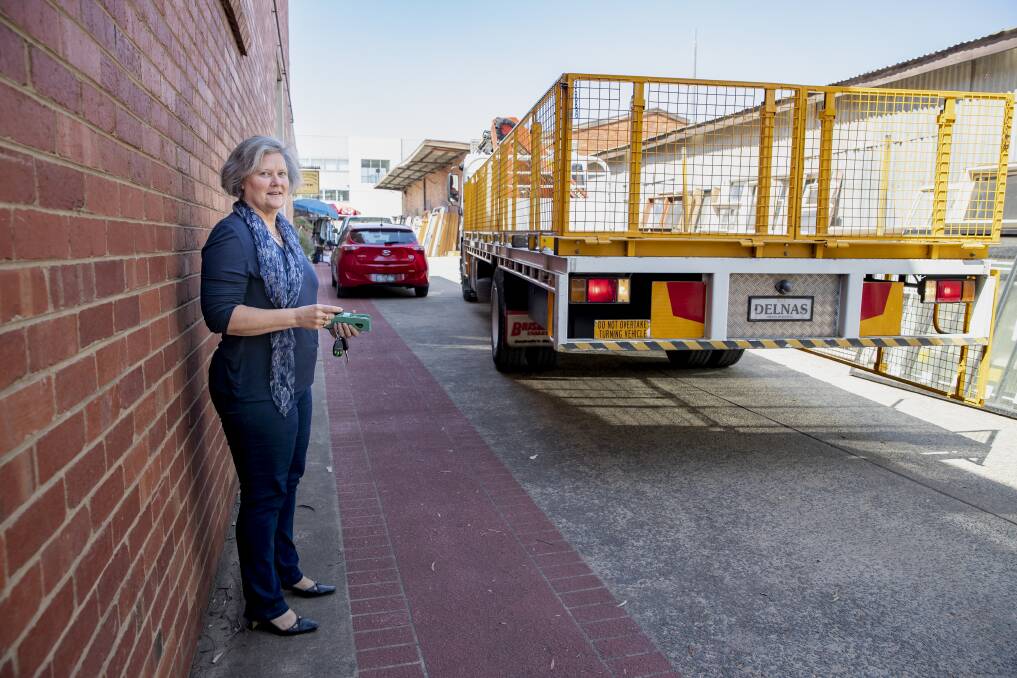 A truck backs up along an easement adjoining Karen Paxton's small business in Fyshwick. The valuation on her block went up 300 per cent in 2016-17, affecting her business. Photo: Sitthixay Ditthavong