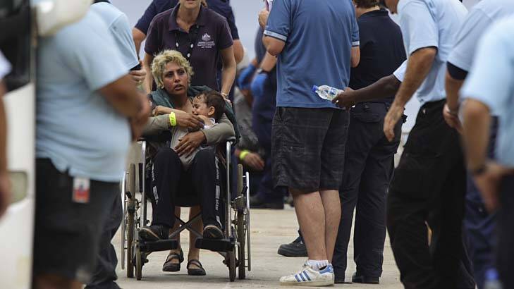 An unknown mother and child are processed by Australian officials after arriving at Flying Fish Cove on Christmas Island. Photo: Wolter Peeters