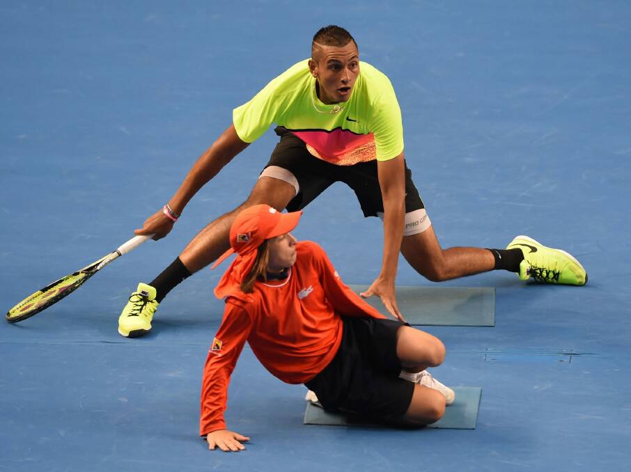 Australia's Nick Kyrgios (top) plays a shot around a ballboy during his men's singles match against Italy's Andreas Seppi on day seven of the January 2015 Australian Open tennis tournament in Melbourne.  Photo: Mildenhall
