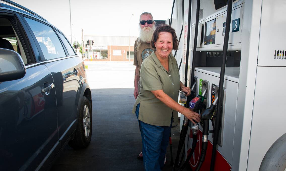 Wayne and Cathie Hines fill up at Queanbeyan Caltex petrol station. The couple always get their fuel in Queanbeyan, where unleaded was an average 6.6 cents per litre cheaper than in Canberra on December 27. Photo: Elesa Kurtz