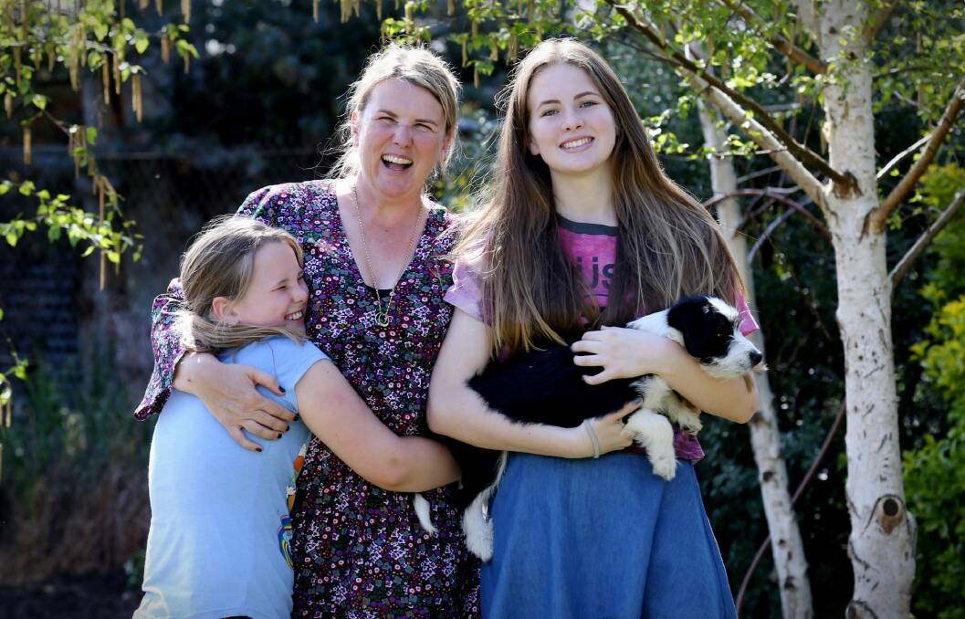 Sue Windsor with her daughters Emma, left, and Jess and their puppy Bruce at their home in Gundaroo. Photo: Andrew Meares