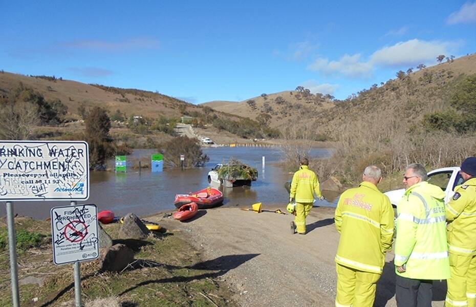 Emergency crew look on as the Hilux is winched back to dry land. Photo: Supplied