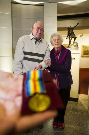 The victory medal, once awarded to Alexander Stuart Burton VC, today donated to the AWM, by John Baker, here photographed with relative of Alexander Burton, Marge Burton. Photo: Rohan Thomson