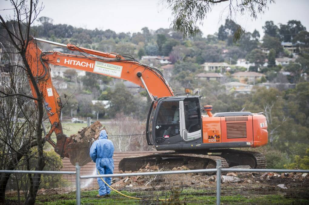 Workers demolish a Mr Fluffy home in the Canberra suburb of Farrer this week. Photo: Rohan Thomson