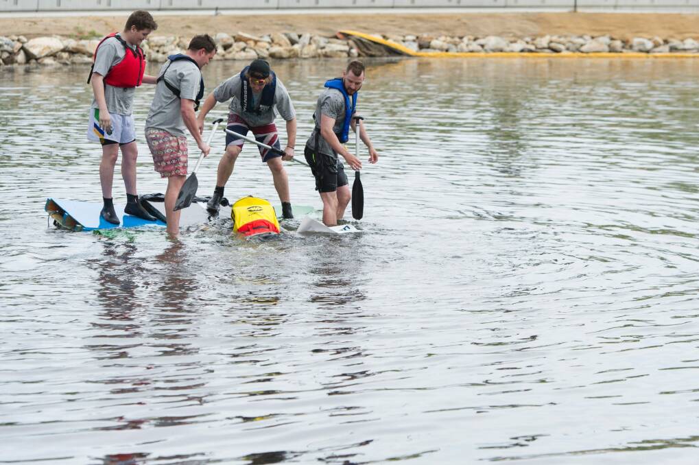 Participants in the boat competition try to save a vessel from sinking at the Queanbeyan River Festival.  Photo: Jay Cronan