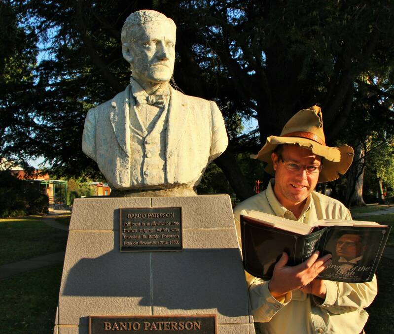 Tim reads some of Banjo's poetry at his statue in Banjo Paterson Park, Yass.  Photo: Dave Moore