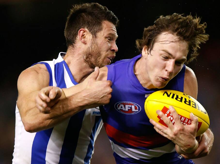 Sam Gibson of the Kangaroos and Liam Picken of the Bulldogs wrestle for possession. Photo: AFL Media/Getty Images