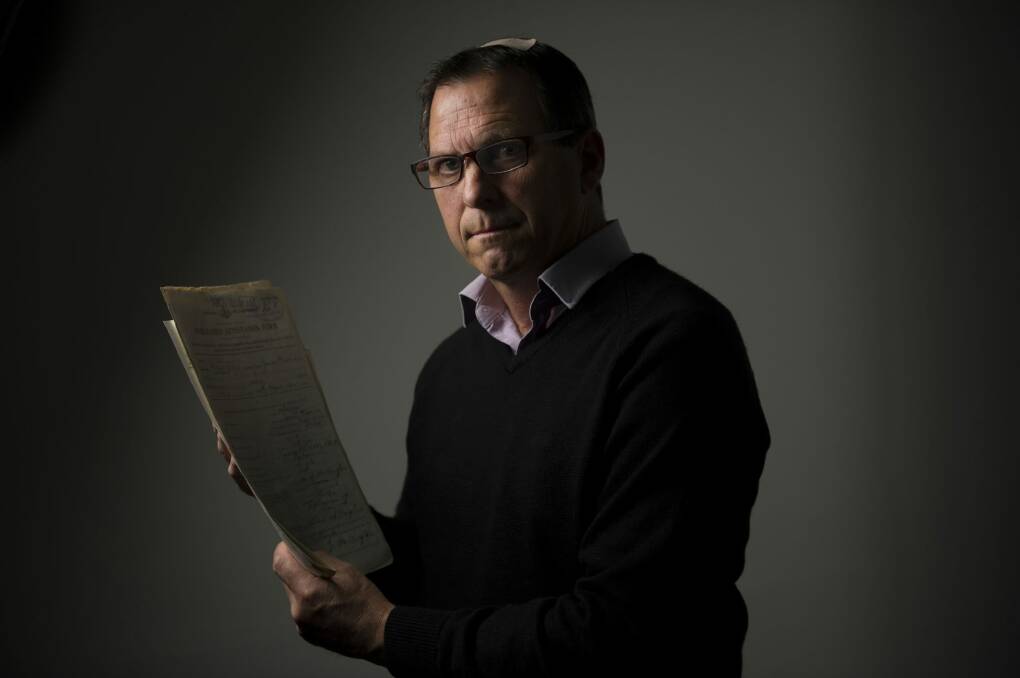 Reference services manager Michael Wenke looking over paperwork and enlistment records from the National Archives' collection. Photo: Jay Cronan