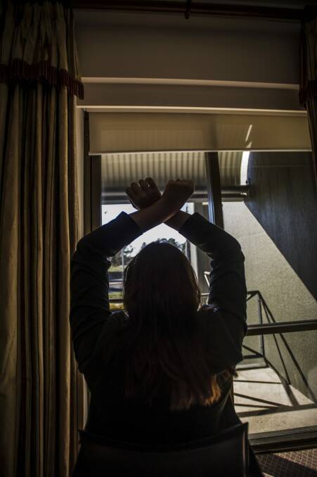 The former care worker demonstrates how the intellectually disabled woman's arms were tied above her head for 30 minutes a time while she was directed to clean the house. Photo: Karleen Minney