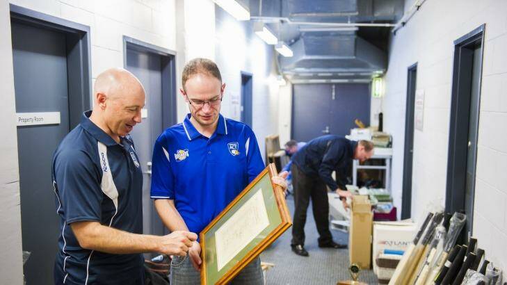 Ben Ryan and Cameron Walter look at the rare discovery: a 1948 team sheet signed by Don Bradman's touring team, The Invincibles. Photo: Rohan Thomson