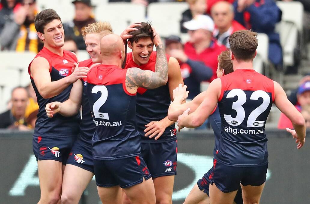 The Demons get around first-gamer Sam Weideman after he kicked a goal with his first kick in the AFL. Photo: Scott Barbour