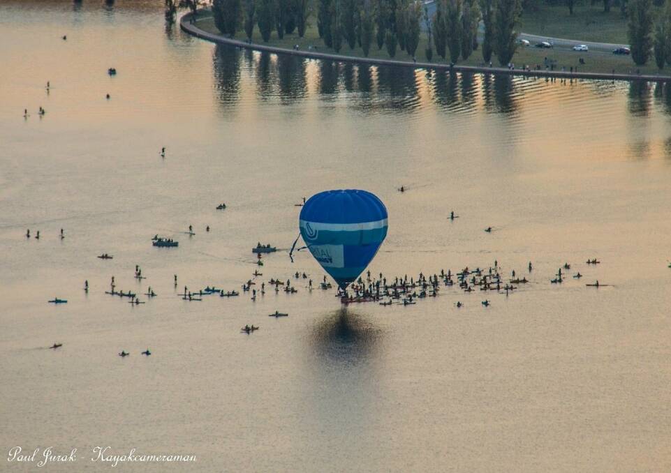 A beautiful shot by Paul Jurak of the Capital Chemist balloon skimming the lake, surrounded by kayaks and stand-up boarders. Photo: Paul Jurak