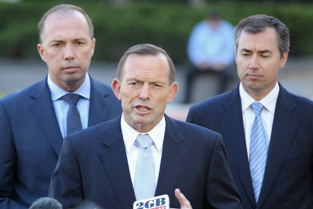 Prime Minister Tony Abbott, flanked by Immigration Minister Peter Dutton and Justice Minister Michael Keenan on Wednesday.  Photo: Alex Ellinghausen