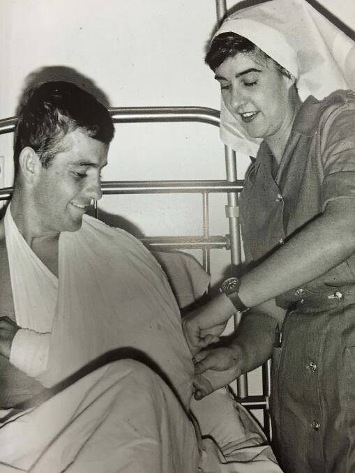 Terrie Ross secures a sling on an Australian soldier at the 8th Field Ambulance, Vung Tau. Photo: Dennis Stanley Gibbons