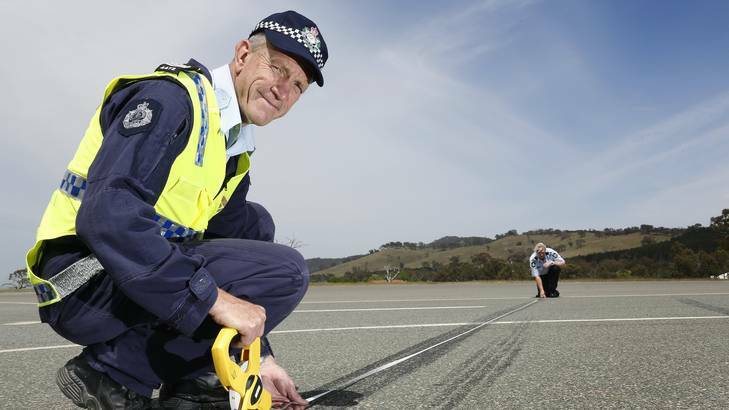Sergeant Dick Dauth and Senior Constable Jane MacKenzie from the Collision Investigation and Reconstruction Team measuring skid marks. Photo: Jeffrey Chan