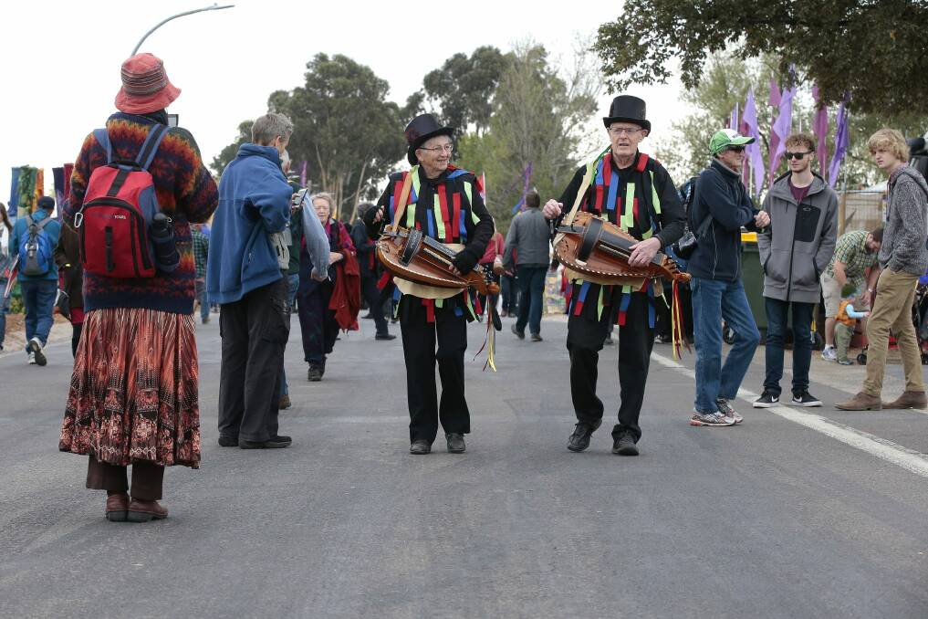 Sue and Jim Colchester of Brisbane from the Border Morris Group play their hurdy gurdy as they move through the crowd.  Photo: Jeffrey Chan