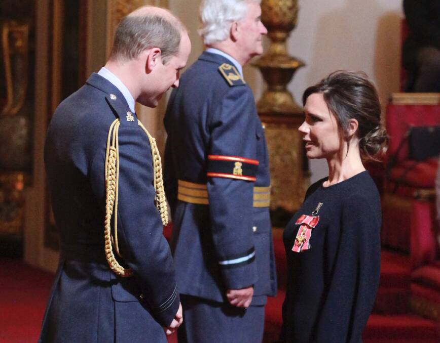 Fashion designer Victoria Beckham receives her OBE from Britain's Prince William, the Duke of Cambridge during an investiture ceremony at Buckingham Palace in London. Photo: YUI MOK