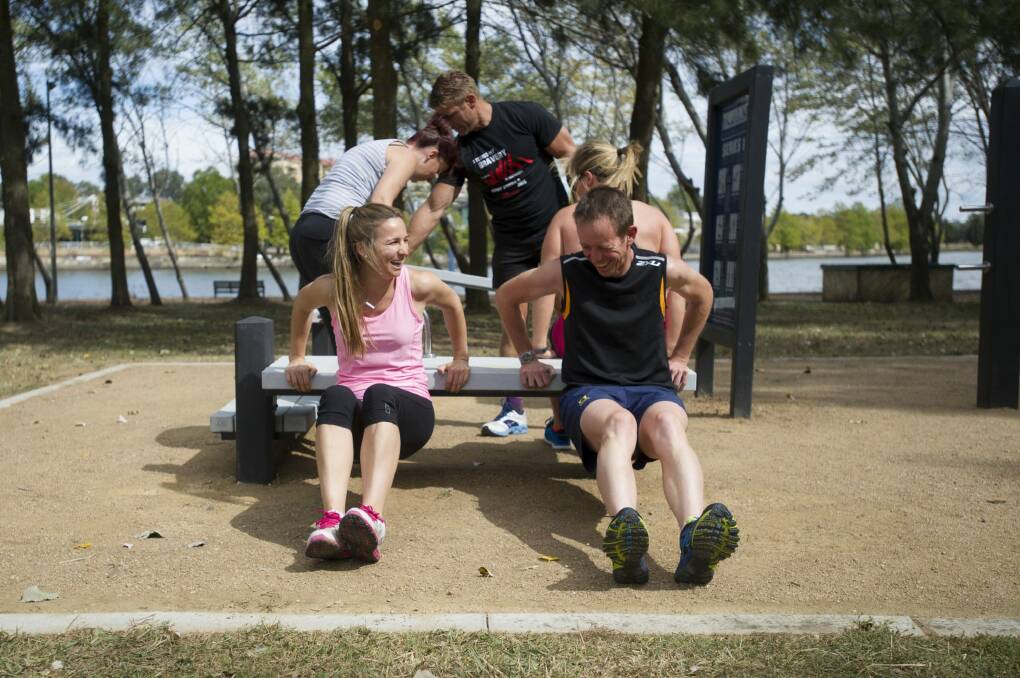 Bella Gay of TAMS and Shane Rattenbury in a group workout session at an older outdoor fitness station. Photo: Jay Cronan